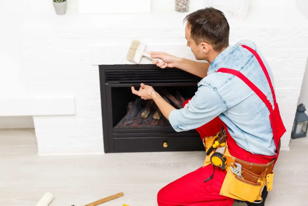 The process of installing the tile on the surface of the fireplace in the house