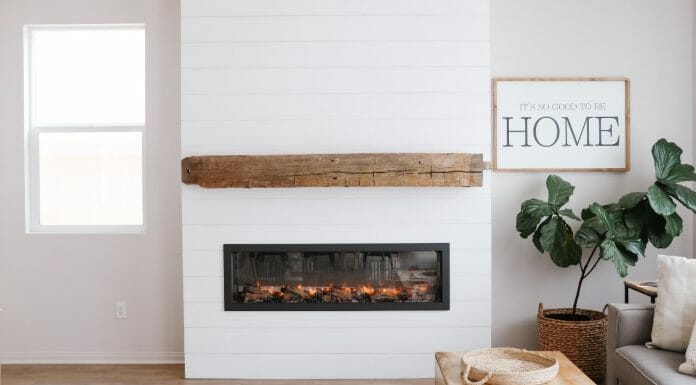 Shiplap Fireplace Ideas + Everything You Need To Know A fireplace in a living room with a wooden mantel.