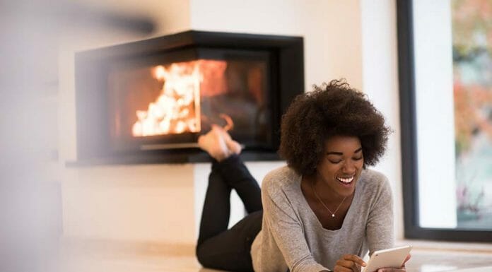 13+ Linear Fireplace Ideas A woman laying on the floor in front of a fireplace.