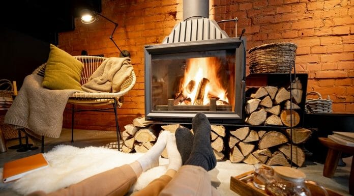5 Ways To Protect The Floor In Front Of Your Fireplace A pair of people sitting in front of a fireplace with logs.